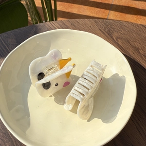 Nahaufnahme von Westie Hund Acetat Haarklammern mit rosa Ohren in einer Schale