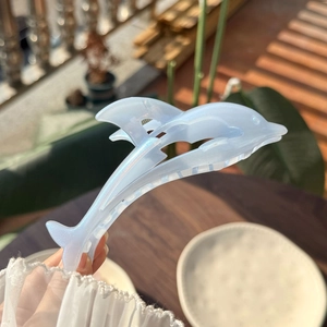 Elegant dolphin-shaped pearlescent blue hair claw clip with a shimmering shell finish