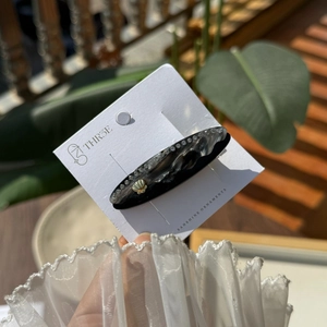 Dettaglio del fermaglio per capelli marmorizzato con strass e conchiglia dorata