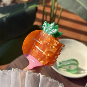Cute carrot-shaped hair claw clip in orange and green acetate with pearlescent finish