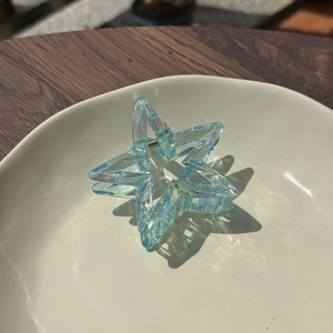 Detailed close-up of iridescent star hair claw clip with colorful refraction effects