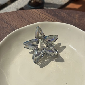 Detail of colorful star shaped hair claw clip with holographic transparent acrylic finish