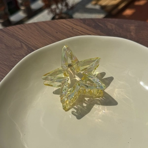 Close-up of a holographic star hair claw clip with clear iridescent acrylic texture