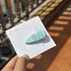 Barrette à cheveux élégante en acétate marbré bleu en forme de goutte sous la lumière
