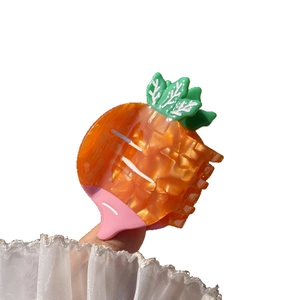 Vibrant carrot-shaped hair claw clip in orange and green acetate for sweet hairstyling