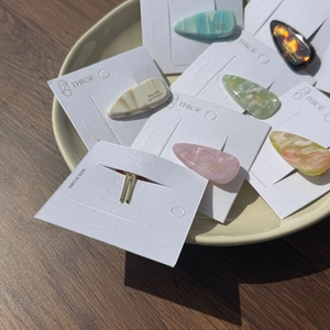 Gros plan de barrettes à cheveux colorées en acétate sur emballage de marque sur bois