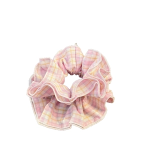 Pink and yellow checkered fabric scrunchie with soft pleated texture and ruffled design
