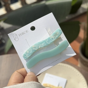 Detail of light blue acetate wavy hair clips set on a branded display card