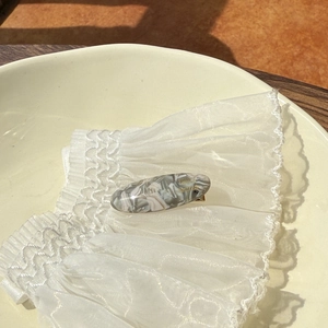 Detail of elegant marble texture acetate hair clip with gold France Handmade lettering