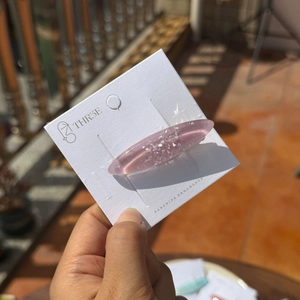 Pince à cheveux rose translucide en résine avec paillettes argentées sur carte
