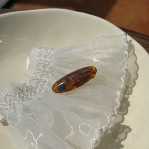 Detailed macro of tortoise shell acetate hair clip with gold France Handmade logo
