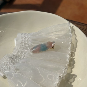 Close-up of marble pattern hair clip with gold metal base and France text detail