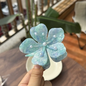 Pince à cheveux fleurie en acétate avec perles et fini marbré bleu et vert