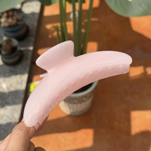 Pink translucent crescent hair claw with fine glitter for thick hair outdoors