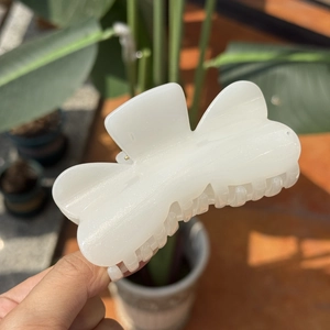 Pince à cheveux nacre blanche en forme de nœud avec paillettes et prise sécurisée