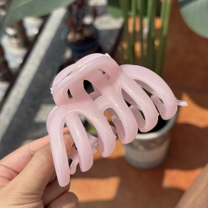 Elegant pink glitter resin hair claw clip for thick hair, shown in natural light