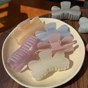 Gros plan détaillé de pinces à cheveux nacrées aux tons macarons avec paillettes fines