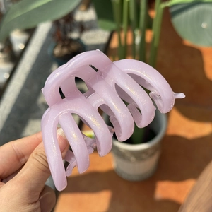 Detail of lavender purple resin hair claw clip with golden glitter and multi-tooth design