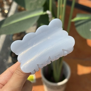 Detailed close-up of blue cloud hair claw clip with subtle glitter finish in sunlight