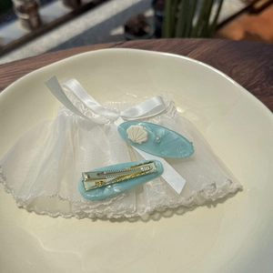 Blue ocean acetate hair clips with shell and pearl accents on elegant display