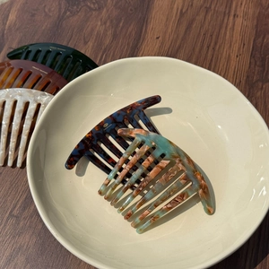 Detail view of handmade acetate hair combs with vintage floral patterns and smooth finish