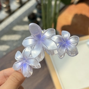 Détail d'une pince à cheveux ornée de trois fleurs dégradées à l'aspect nacré
