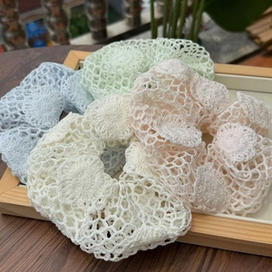 Détail de quatre chouchous au crochet faits main aux couleurs pastel avec texture florale