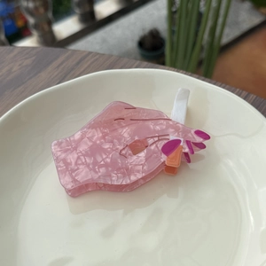 Unique hand-shaped hair claw clip with pink marble finish and cigarette design feature
