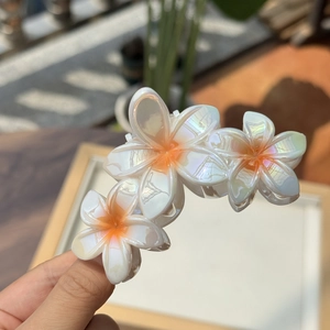 Detailansicht der irisierenden Blumen-Haarklammer mit drei weißen Plumeria-Blüten
