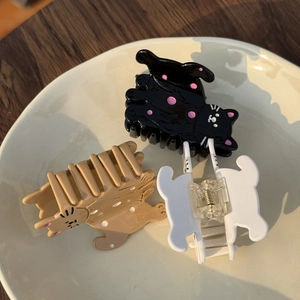 Trois pinces à cheveux en forme de chat avec pois et couleurs unies sur un plat en céramique