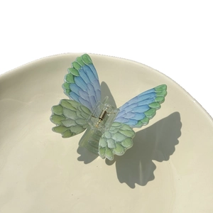 Elegant acrylic butterfly hair claw clip with blue-green gradient and feather texture