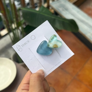 Dettaglio di fermagli per capelli a cuore blu con margherite essiccate e oro