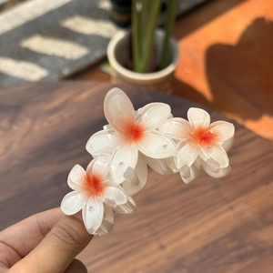 Détail d'une pince à cheveux florale texture gelée avec trois fleurs dégradé orange