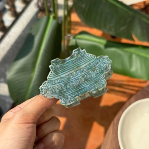 Detail of a bronze-green acetate claw clip with traditional Chinese auspicious cloud patterns