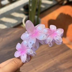 Vue détaillée de la pince à cheveux triple fleurs de frangipanier rose nacré
