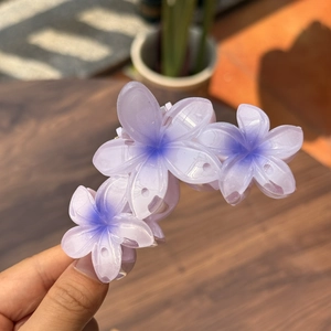 Détail d'une pince à cheveux à trois fleurs avec effet gelée dégradé violet
