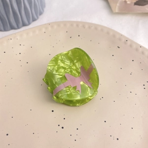 Pince à cheveux en acrylique marbré vert avec nœud rose sur plateau en céramique