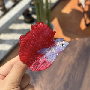 Detail of betta fish hair claw clip made of red and purple acetate resin material