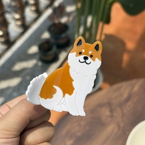Detail van de Shiba Inu haarclip van acetaat met een glanzende oranje en witte afwerking