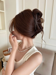 Elegante molletta per capelli a fiocco marrone scuro su acconciatura raccolta francese