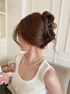 Dettaglio di un elegante fermaglio per capelli a fiocco marrone scuro effetto ambra