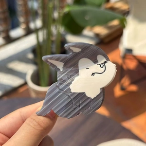 Detail van een hondvormige acetaat haarklem met husky-patroon en stevige metalen sluiting