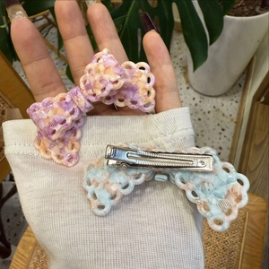 Dettaglio del fermaglio per capelli a fiocco intrecciato in colori macaron con base in metallo