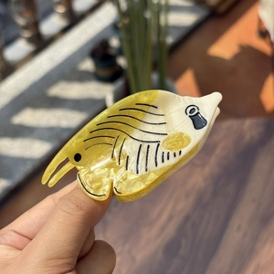 Detailed close-up of a yellow tropical fish hair claw clip made of acetate material