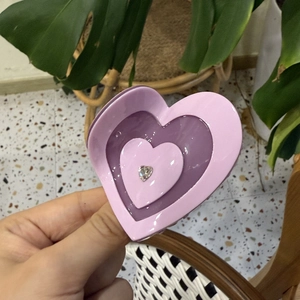 Détail d'une pince à cheveux en acétate violette en forme de cœur avec strass scintillant