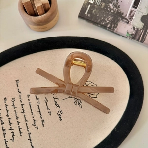 Dettaglio di un fermaglio per capelli a fiocco ambra su un piatto decorativo retro