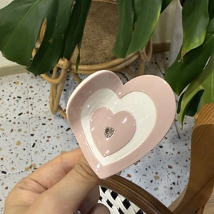 Détail de la pince à cheveux en forme de cœur rose et blanc avec strass brillant