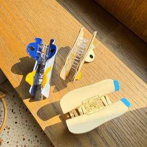 Dettaglio di fermagli per capelli in acetato con disegni animati su base di legno