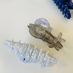 Detail of marble pattern and translucent grey acetate hair claws with gold springs