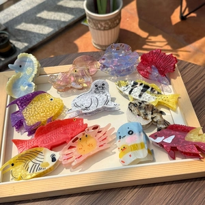 Various acetate hair claws featuring ocean creatures like seahorses and octopuses